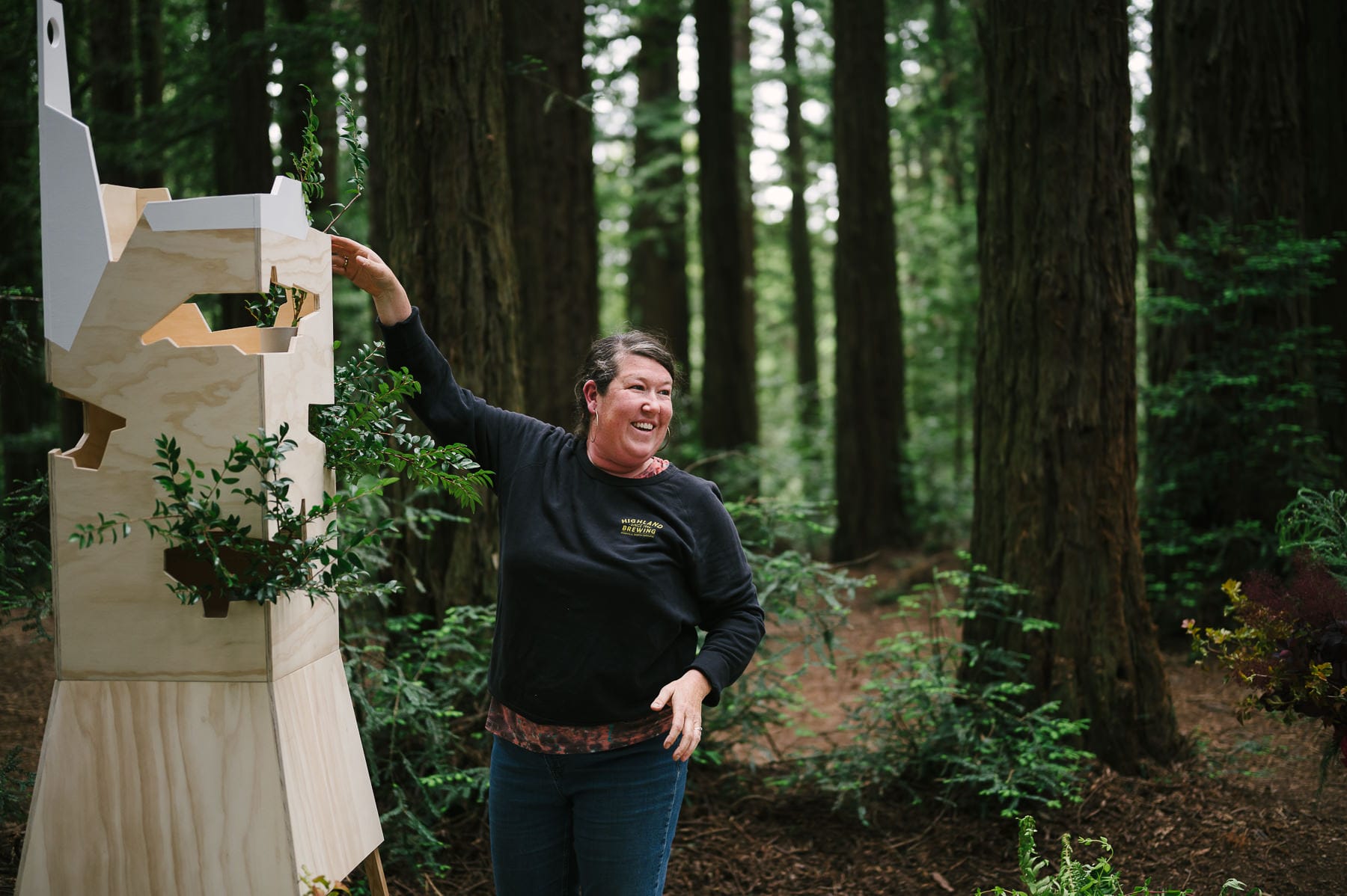 Florist, Alyson Vitt, adds flowers to a custom built box in the redwoods for a wedding at Roberts Regional Recreation Area in Oakland.