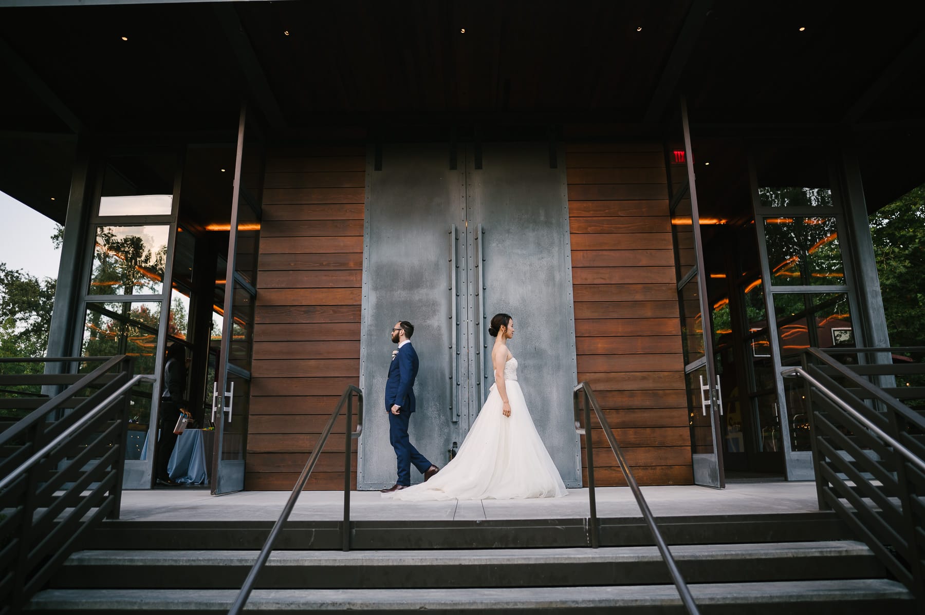 Wedding couple framed by large metal doors at the top of stairs at La Crema wedding in Windsor