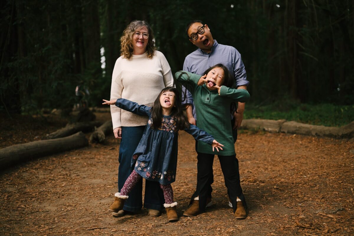 Parents and two daughters making goofy faces for family mini portrait session in Redwoods in Oakland