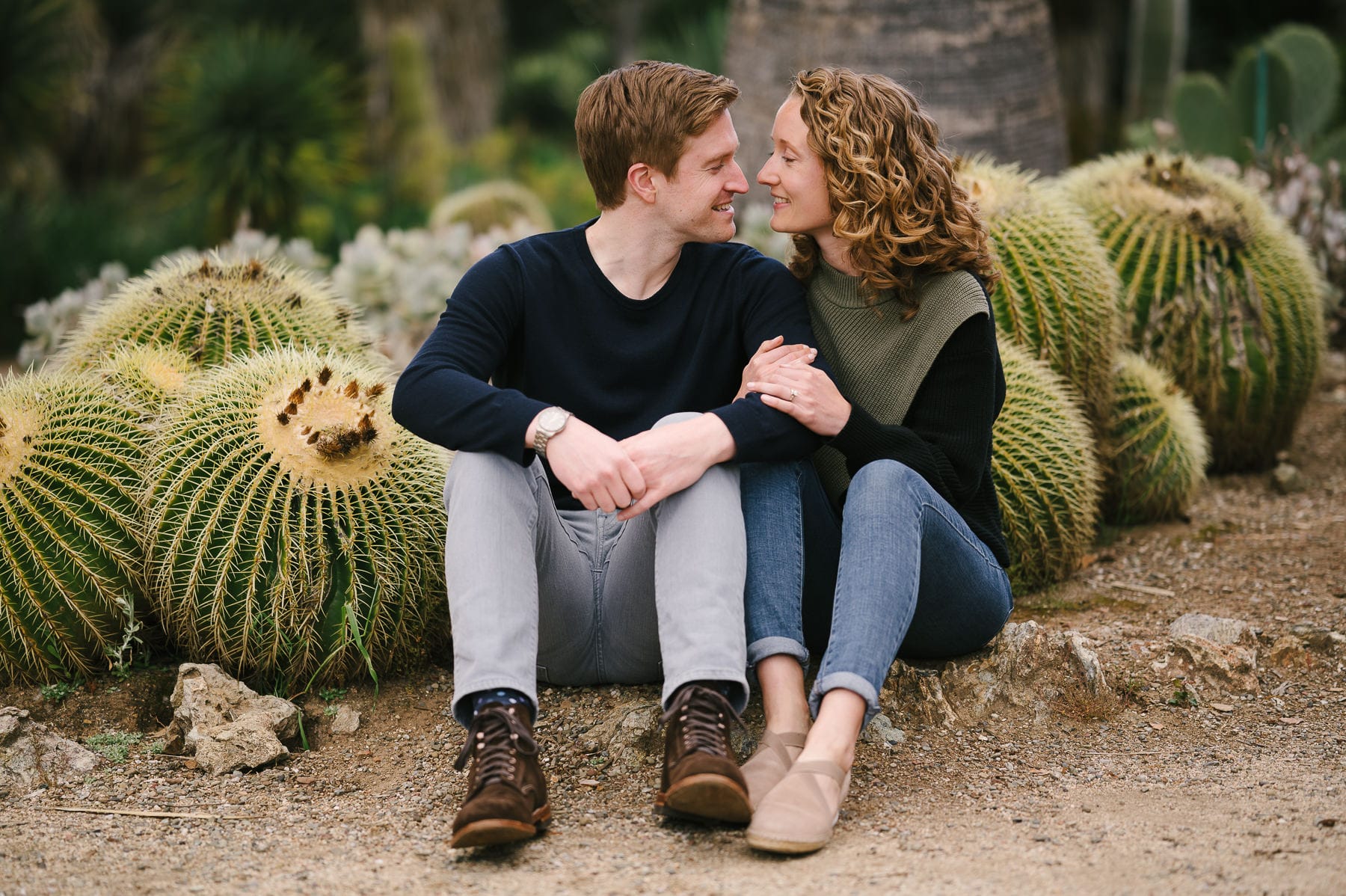 Couple sitting in cactus garden at engagement session in Standford.